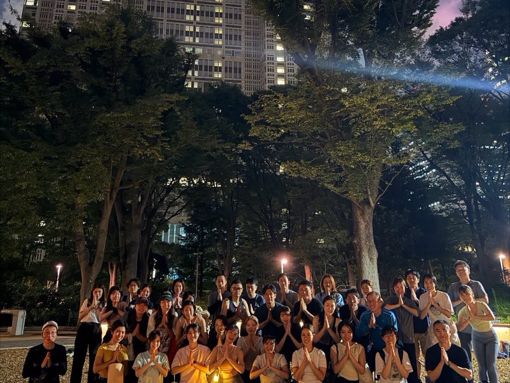 夜のクラスのあとの集合写真。参加者が並んで合掌しているところ